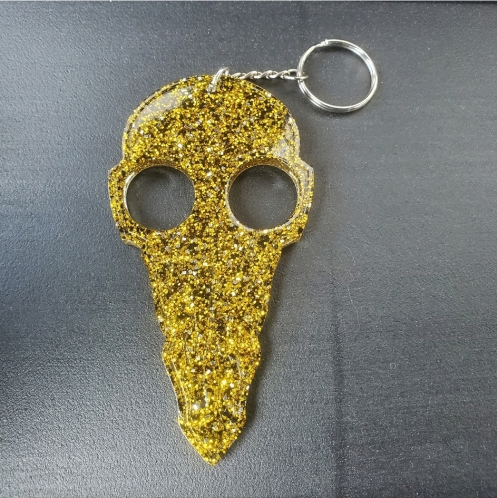 Self defense bird skull key chain with gold, back and silver glitter.